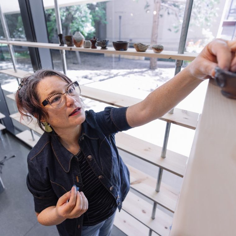 Erika Chong Shuch, Stanford Arts' 2025–26 visiting artist, attends the installation of her exhibition 1,000 Ways to Hold at the Anderson Collection at Stanford University. The show is the culmination of a year-long participatory project rooted in conversation and clay, in which pairs of participants shaped ceramic bowls while reflecting on questions of memory, care and human connection.