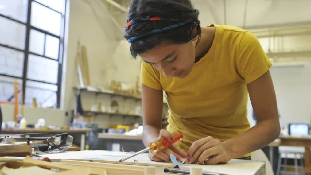 A woman designing wood work during Arts Intensive